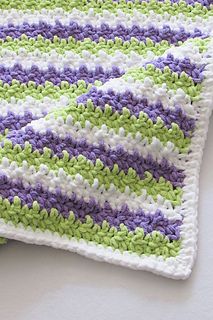 a crocheted blanket laying on top of a table