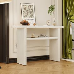 a white table sitting in the middle of a living room next to a green curtain