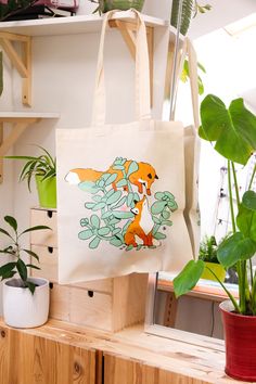 🦊 Fox Plant Tote Bag 🦊 All designs are digitally hand drawn by me and the Bags are handprinted in my studio. Oh and every order comes with a freebie sticker ☻ All my Designs are digitally drawn on an iPad with Procreate.  ✸ Details ✸ ~ 38x40cm ~ eco-friendly natural cotton tote bag ~ very lightweight, easy to fold up and perfect for your handbag ~ 130gsm Cotton ✸ Packaging ✸ The whole package will be as eco friendly as possible.  ✸ Note ✸ Depending on the screen settings, the colors might differ slightly.  Don't hesitate to contact me with any questions. Thank you for stopping by <3 Instagram: @madivoid_ Patreon: @madivoid White Screen Printed Bag As Gift, White Screen Print Bag As Gift, Rectangular Bags With Screen Print For Daily Use, Eco-friendly Screen Print Bags For Daily Use, Eco-friendly Screen Print Bag For Daily Use, Cotton Packaging, Decorated Tote Bags, Animal Design Tote Bag For Travel, Eco-friendly Rectangular Bag With Cat Design