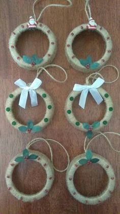 four christmas wreath ornaments hanging from twine