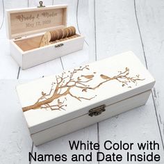 a white box with gold painted branches and birds on it next to a wooden box that says, white color with names and date inside