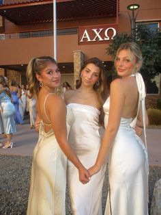 three beautiful young women standing next to each other