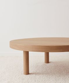 a wooden table sitting on top of a white carpet