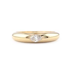 a yellow gold ring with a single diamond in the center, on a white background