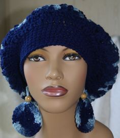 a mannequin head wearing a crocheted blue hat with earring and earrings