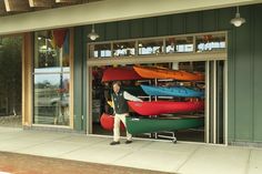 a man standing in front of a store with kayaks