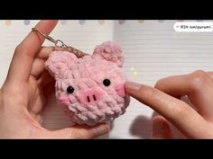 a hand holding a small pink pig keychain