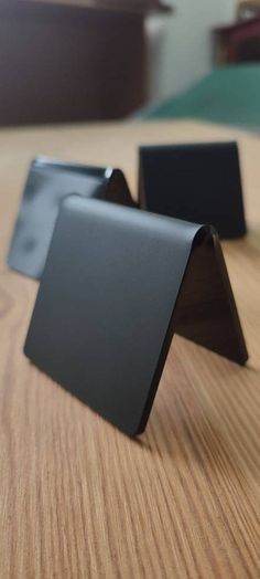 two black business cards sitting on top of a wooden table