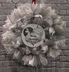 a christmas wreath on a brick wall with the words merry christmas written in white and red