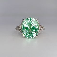 "While Supplies Last! This ring is an oval lab created right green paraiba with round moissanite accents, 14k white gold #6401 -Approximate total carat weight:  6.05ctw diamond equivalent  -Center Stone Size:  12x10mm - approx. 5.80ct diamond equivalent  -Center Stone Shape: oval  -Gem Type:  Lab Created Tourmaline Paraiba Corundum  -Treatment: Nanocrystal -Stone Clarity: VS2 -Stone Color: Light Green/Mint Green -Moh's Scale: 7 Hardness -Side Stones: round  - approx. 0.25ct diamond equivalent -G Esty Finds, Green Diamond Rings, Oval Engagement Ring, Green Garnet, Oval Engagement, Green Mint, Ring Light, Round Moissanite, Engagement Rings Oval