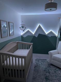 a baby's room with mountains painted on the wall and a crib in the foreground