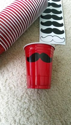 two red cups with mustaches on them are sitting on the floor