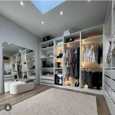 a large walk in closet with lots of clothes