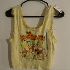 New Women’s Cropped Baby Tank. This Has A Retro Beach Themed Flintstone Design. The Color Is Called Mellow Yellow & Is A Baby Yellow. The Neckline & Straps & Both Lace Lined. Yellow Y2k Tank Top For Summer, Retro Yellow Tank Top For Spring, Vintage Yellow Top For Beach, Vintage Yellow Top For The Beach, Vintage Yellow Tops For Beach, Fun Yellow Sleeveless Top, Casual Yellow Tank Top With Graphic Print, Fun Yellow Summer Top, Yellow Tank Top With Graphic Print For Spring