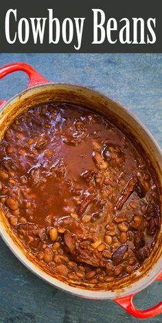 a red pot filled with chili beans on top of a wooden table next to a black and white sign that says cowboy beans