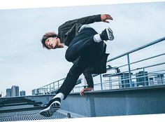 a man riding a skateboard down the side of a metal rail on top of a building