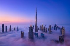 an aerial view of skyscrapers above the clouds at sunset in dubai, united kingdom