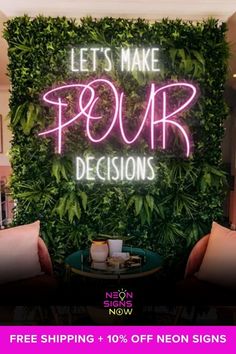 a neon sign that says let's make pour decisions on it and two pillows in front