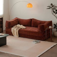 a living room with a couch, coffee table and bookshelf on the floor