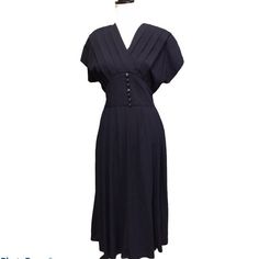 "Navy vintage dress with pockets. Dress from 70s/80s. Decorative Buttons. Zippered Back.    Brand: Kathie Lee   Size: Tag Sizing is 6. See Measurements for more details.    Material: 85% Polyester, 35% Rayon   Condition: Great Condition, don't notice any flaws.    Measurements:  Bust: 40\"  Length: 49\"  Waist: 24\"  Hip: 48\"" Retro V-neck Dress With Buttons, Vintage Fitted V-neck Midi Dress, Retro A-line Vintage Dress For Formal Occasions, Vintage A-line Dress For Work, 1950s Style Formal Midi Dress, Vintage V-neck Midi Dress For Evening, Retro A-line Vintage Dress For Work, Fitted 1950s V-neck Dress, Classic Vintage Midi Dress For Formal Occasions