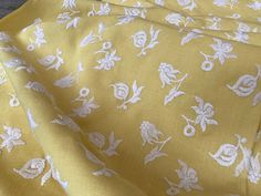 the fabric is yellow with white flowers on it