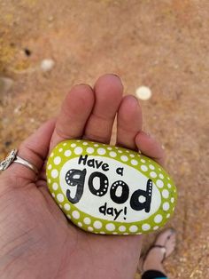 a hand holding a rock that says have a good day