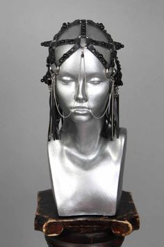 This is a one of a kind piece of wearable art made for the Five and Diamond Seventh Annual Headgear Art Show and shown on August 2, 2019. Black leather head piece made by entirely by hand. Designed by Darmara One of a kind Unisex MATERIALS USEDGenuine leather, metal rivets, stainless steel chains, black pearl rivets. WEARING INSTRUCTIONSAvoid getting piece wet.To clean, wipe down with a wet cloth then a dry cloth. Store in a dry place. All headgear sales are final. Due to the unique nature of th Handmade Adjustable Headpieces For Evening, Handmade Adjustable Evening Headpieces, Gothic Leather Jewelry For Party, Handmade Black Headpieces For Party, Handmade Black Festival Headpieces, Handmade Gothic Headpiece For Party, Ceremonial Black Adjustable Headpieces, Adjustable Black Ceremonial Headpiece, Handmade Black Fantasy Headpieces