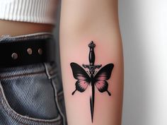 a black and pink butterfly tattoo on the left arm with a knife in it's center