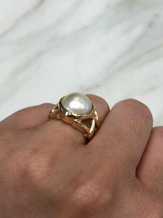 https://www.youtube.com/watch?v=LmsKK0XX-NQ Displayed is a contemporary Mabe pearl and gold solitaire ring. The natural center stone has a beautiful cream color and impressive size. The pearl measures an exact 14.0mm x 14.0mm and is breathtaking. Steadily put, the mabe pearl is held in a secure 14K yellow gold bezel creating a modern and sleek look. To further its beauty, the ring is accented by marvelous gold work that resembles bamboo or a complex structure. The ring is ideal for everyday use Luxury 14k Gold Pearl Ring With Polished Finish, Luxury 14k Gold Pearl Ring, 14k White Gold Rings With High Luster, Timeless 14k Gold Jewelry With High Luster, Luxury 14k Gold Hallmarked Pearl Ring, Luxury Hallmarked 14k Gold Pearl Ring, Unique 14k Yellow Gold Pearl Ring, Luxury White Ring Stamped 14k, Luxury White 14k Stamped Diamond Rings