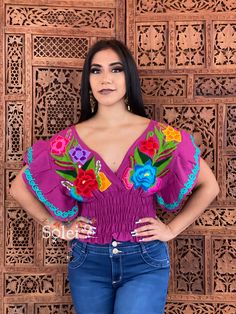 This beautiful Butterfly Sleeve Crop Top is the perfect Top for a fun day out or special event. The adorable fluttery sleeves and colorful embroidered flowers make it flirty and fun. It's made out of cotton, has an elastic waist and has colorful flowers embroidered by Artisanal Machine. This blouse is made with love by Mexican Artisans in Chiapas, Mexico. Please note: This blouse comes in one size which fits sizes Small and Medium. Purchase the gold plated filigree earrings here: https://www.ets Fitted Purple Embroidered Tops, Fitted Embroidered Purple Tops, Low Cut Crop Top, Frida Kahlo Style, Flowers Embroidered, Mexican Blouse, Floral Embroidered Top, Butterfly Sleeve, Floral Butterfly