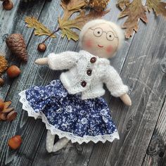 the doll is wearing a blue dress and white sweater