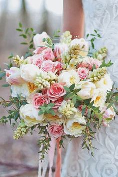 a bridal holding a bouquet of pink and white flowers