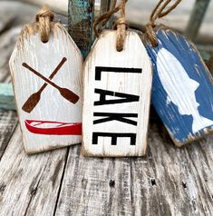 three wooden tags with canoe and kayak designs