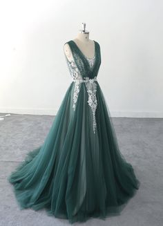 a green dress with white lace on the waist and back, sitting on a mannequin