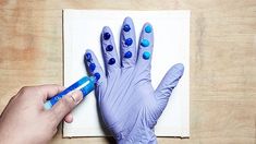 a person in blue gloves holding a marker