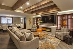 a living room filled with furniture and a flat screen tv mounted on the wall above a fireplace