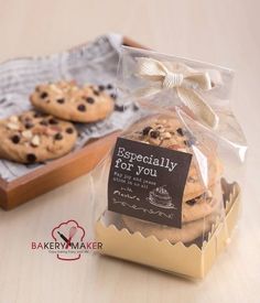 two cookies wrapped in cellophane and tied with a bow, sitting next to each other on a table