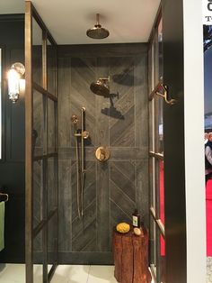 a walk in shower sitting next to a wooden stump on top of a tiled floor