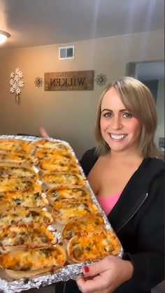 a woman is holding up a tray of food