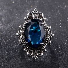 This gorgeous sterling silver ring is perfect for a person with a flare for vintage jewelry. The Blue Sapphire Peacock Vintage Ring features an oval blue sapphire as its centerpiece, encircled by small round white diamonds that catch the light gloriously and radiate life! From cornflower blue to velvety blue, there are multifarious shades of blue sapphire that gives it a silky tint. Characterized by the power of Shani or Saturn, Blue Sapphire displays violet to indigo and pale blue as well as da Sapphire Rings For Women, Sapphire Silver Ring, September Birthstone Rings, Sapphire Rings, Vintage Sapphire, Blue Gems, Unisex Ring, Lovely Ring, Anniversary Party