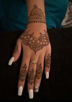 a woman's hand with henna tattoos on it