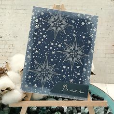 a card with snowflakes on it is sitting in a bowl filled with cotton balls