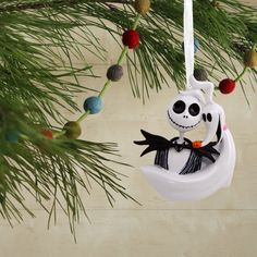 an ornament hanging from a christmas tree with a jack skellingy decoration