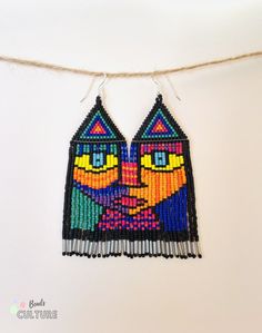 a pair of colorful beaded earrings hanging from a string