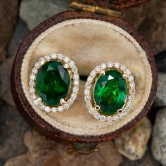 These colorful stud earrings are each centered with an oval mixed cut tsavorite garnet in a four-prong setting. The center is surrounded by a halo, shared prong set with twenty-four (24) round brilliant cut diamonds. The earrings measure 12.2mm long by 10.2mm wide and 5.6mm deep, finished with posts and friction nut backs. Elegant Oval Tsavorite Jewelry, Tsavorite Earrings For Anniversary In Fine Jewelry Style, Oval Tsavorite Jewelry For Anniversary, Diamond Halo Earrings, Colorful Stud Earrings, Halo Diamond Earrings, Gem Jewelry, Peridot Jewelry, Tsavorite Garnet