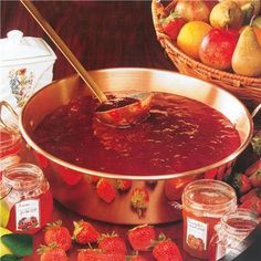 a large pot filled with liquid surrounded by fruit