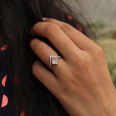 a woman's hand with a diamond ring on her finger