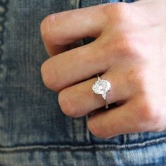 a person's hand with a diamond ring on it