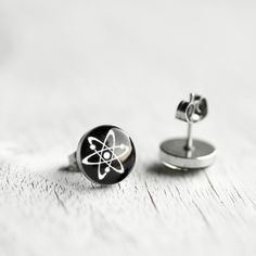 "Lovely pair of handcrafted earrings featuring the Atom Symbol. Made of 100% hypoallergenic SURGICAL STAINLESS STEEL and RESIN. Perfect for everyday wearing to office and for any other occasions. More SCIENCE: http://etsy.me/1Bl2PNO More GEEKERY: http://etsy.me/1pEBcGL More STUD earrings: http://etsy.me/Ym7FfT DIMENSIONS - 7mm / 10 mm / 12 mm (0.27\" / 0.4\" / 0.5\") in diameter MATERIALS - glossy, jewelry grade resin, that makes the earrings durable but light weight, as well as water resistant Minimalist Surgical Steel Earrings As Gift, Nickel-free Surgical Steel Plug Earrings For Gift, Nickel-free Stainless Steel Plug Earrings As Gift, Nickel-free Stainless Steel Plug Earrings Gift, Internally Threaded Metal Plug Earrings As Gift, Atom Symbol, Mens Earrings, Unisex Earrings, Tiny Earrings