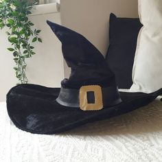 a black hat sitting on top of a bed